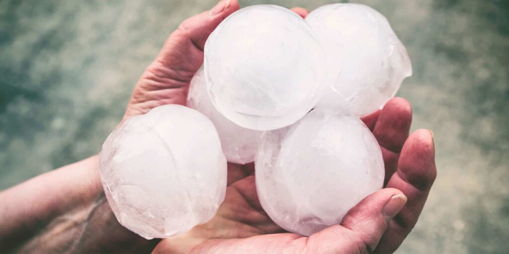 person holding large balls of hail