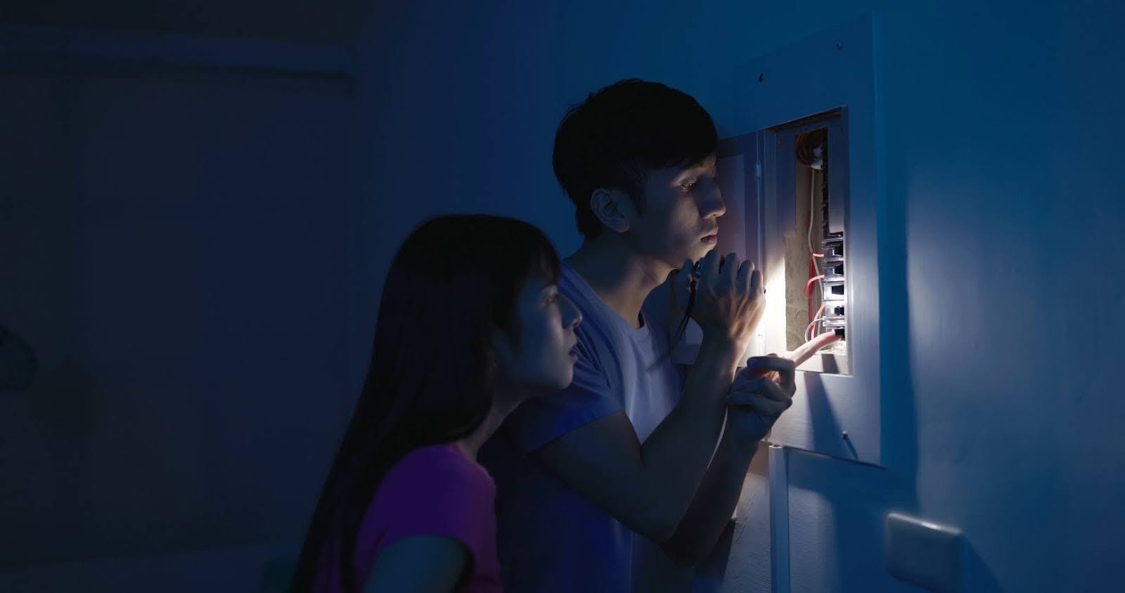Couple checking power box during a power outage in Colorado showing the need for solar power